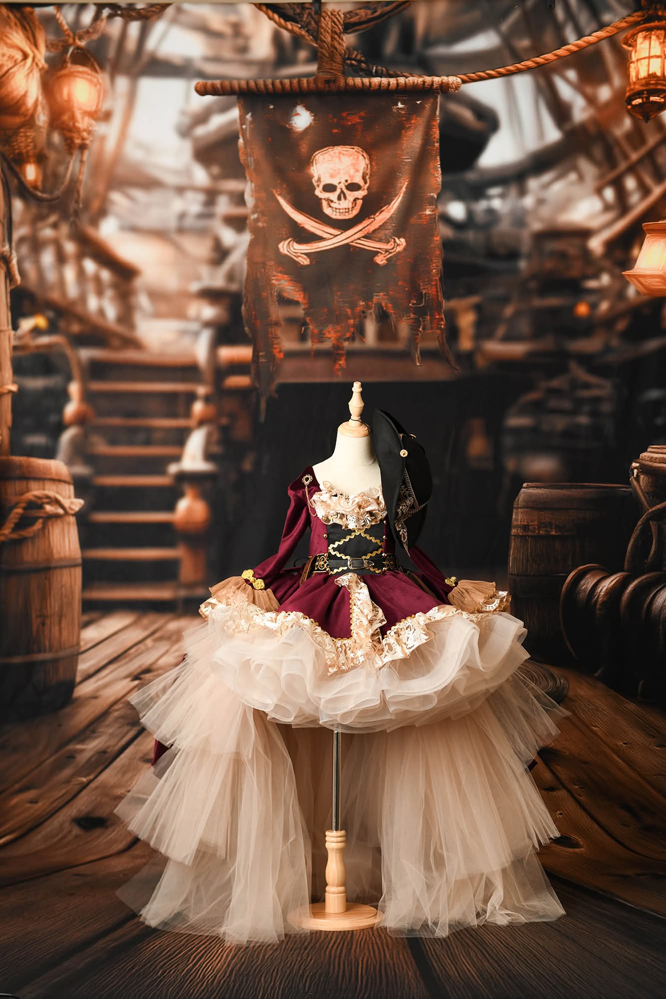 Pirate-themed setting with a doll in a costume on a ship deck, featuring a skull and crossbones flag.