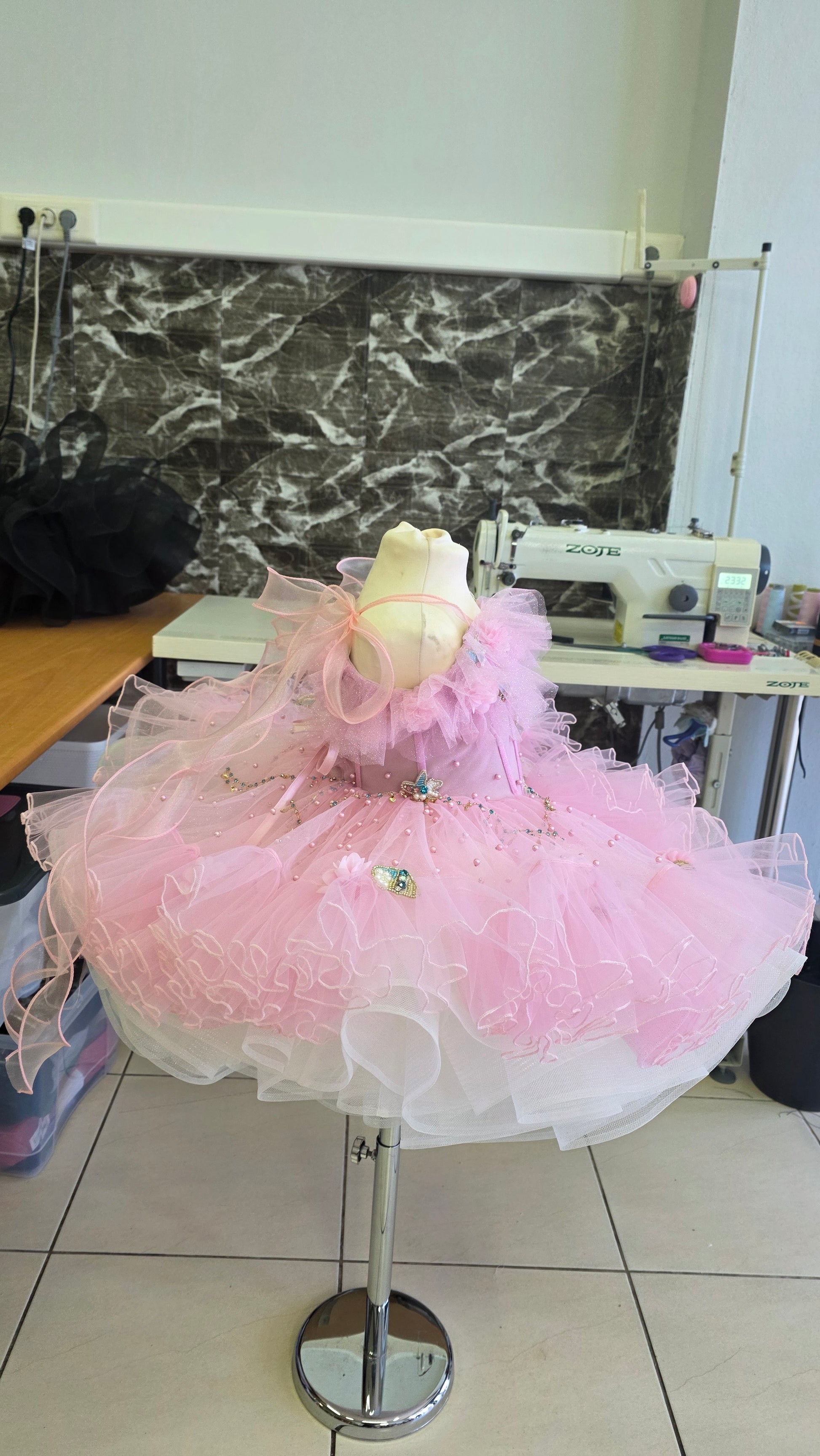 pink and white girls dress on a manequin