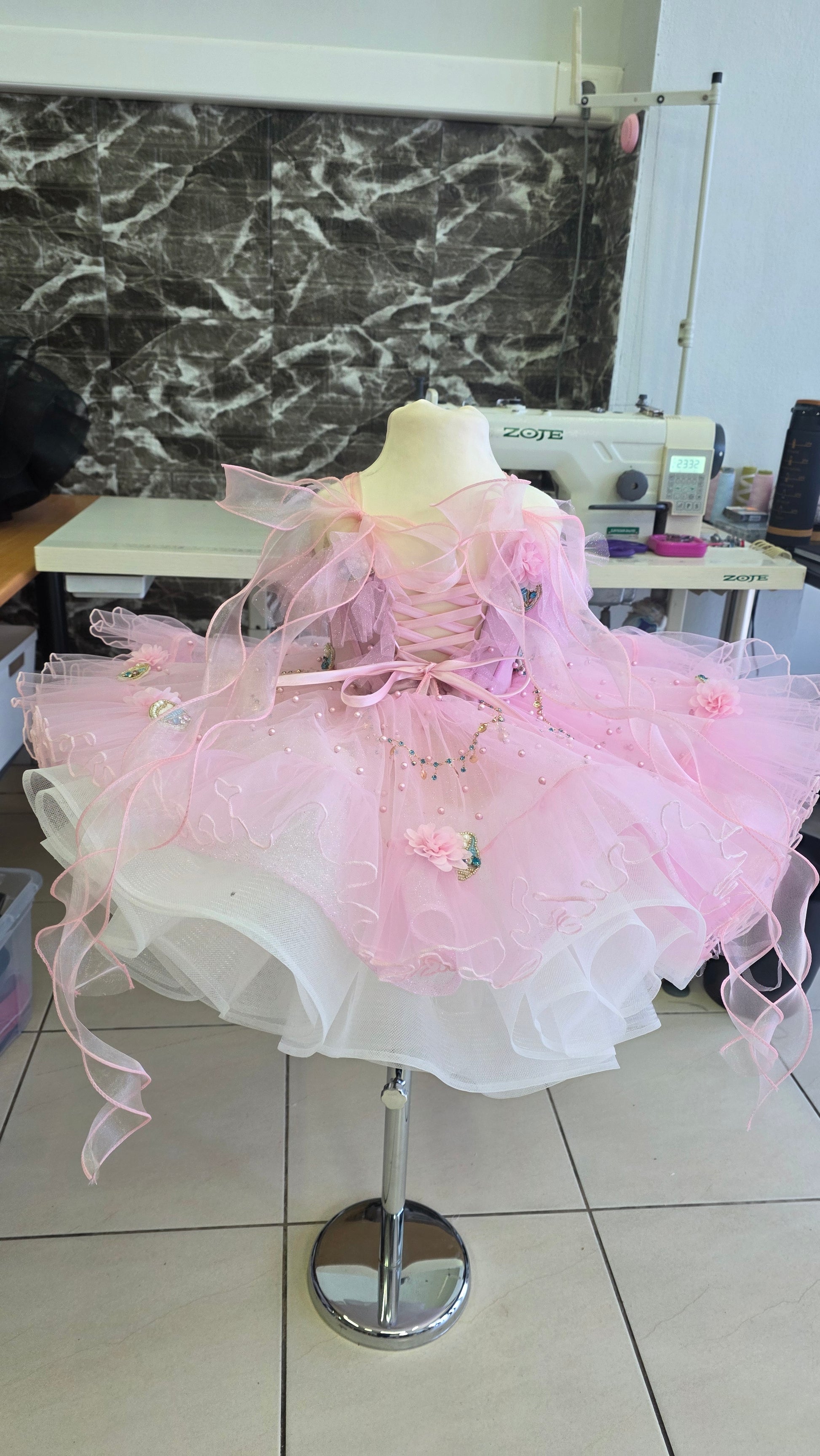 pink and white girls dress on a manequin